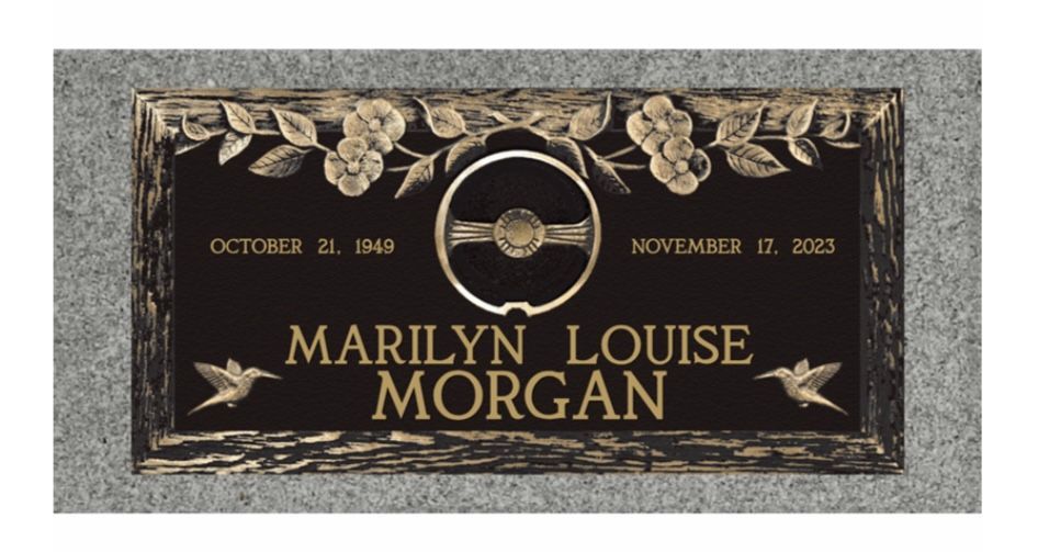 Black and gold memorial plaque for Marilyn Louise Morgan with dates and a central emblem