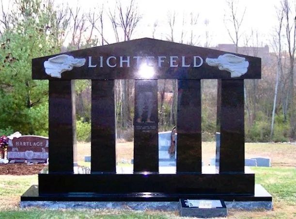 Black memorial with “LICHTFELD” and vertical glass panels outdoors