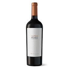 Botella de vino Alma Mora con tapón de cobre y etiqueta blanca.