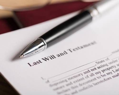 Close-up of a Last Will and Testament document with a pen resting on top.