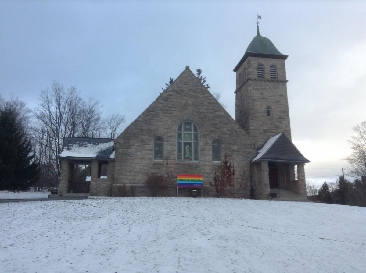 A church with a rainbow flag in front of it