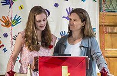 Two women are standing next to each other in front of a podium.
