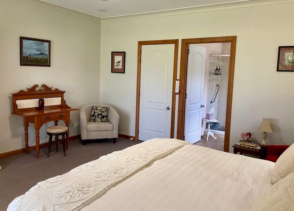 Bedroom with a desk, chair, and bed. Doorway leads to a bathroom. Norfolk Island Trade Winds Seniors Sanctuary Flinders