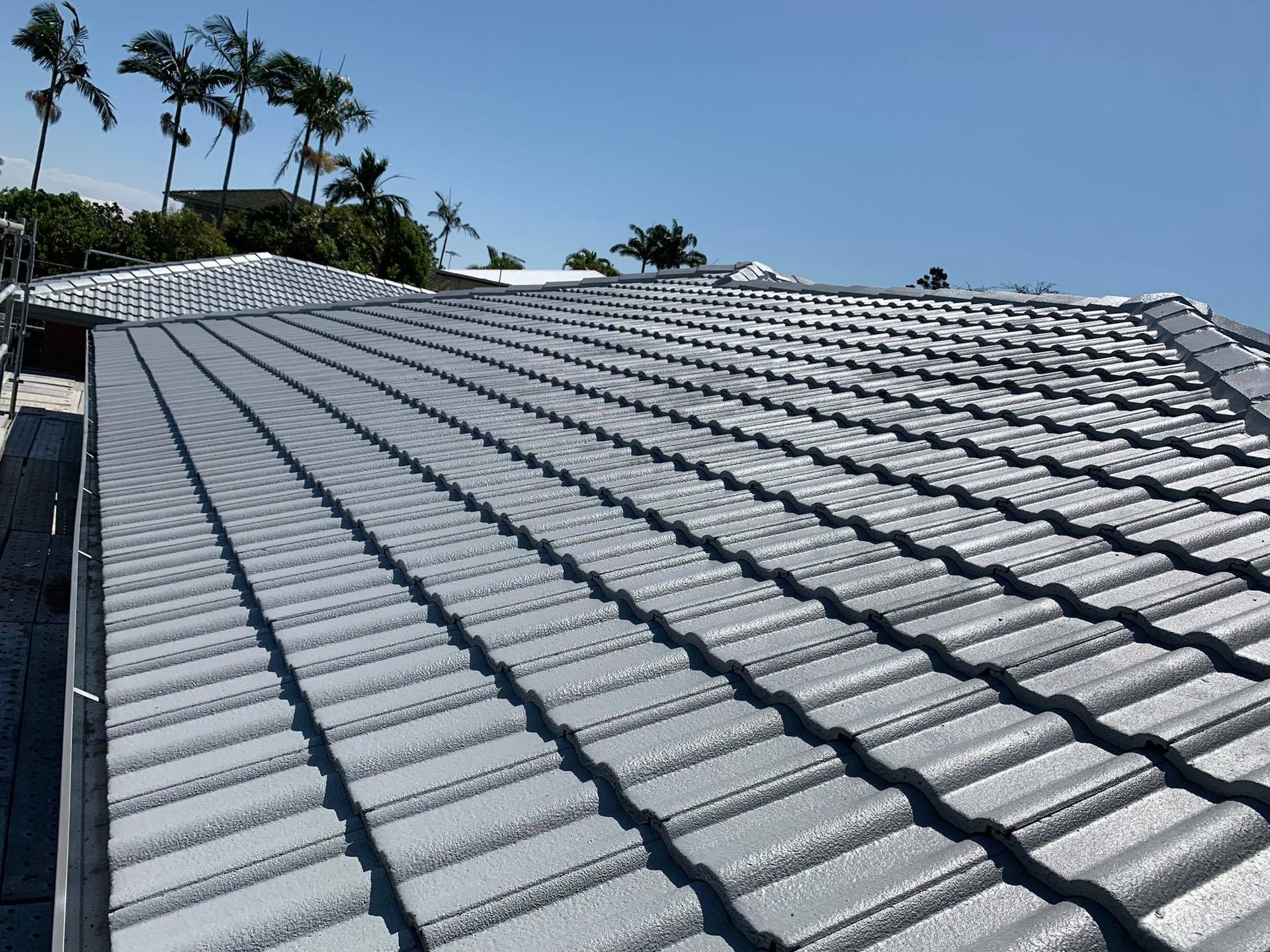 Grey Tiled Roof of a House Under a Clear Blue Sky — Roof Tek CQ in Rockhampton, QLD