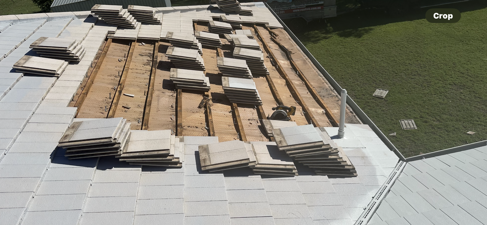 Roof partially disassembled with stacked tiles and exposed wooden beams, outside — Roof Tek CQ in Gracemere, QLD