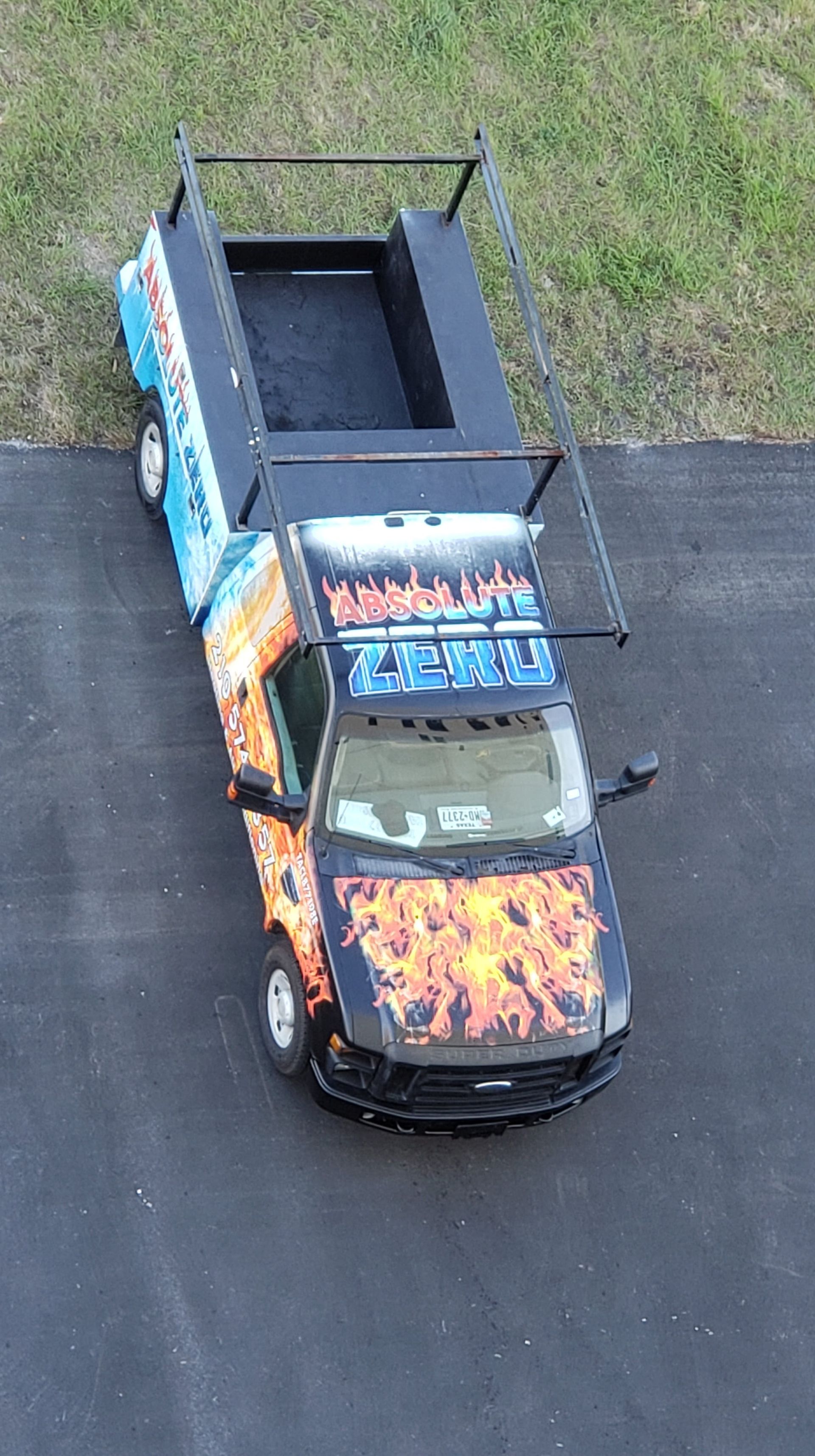 A truck with flames painted on it is parked on the side of the road.