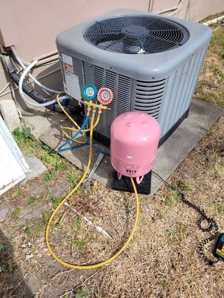 Air conditioning unit with gauges and pink recovery tank.