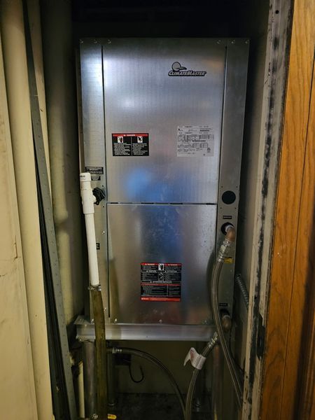 Silver HVAC unit in a utility closet.