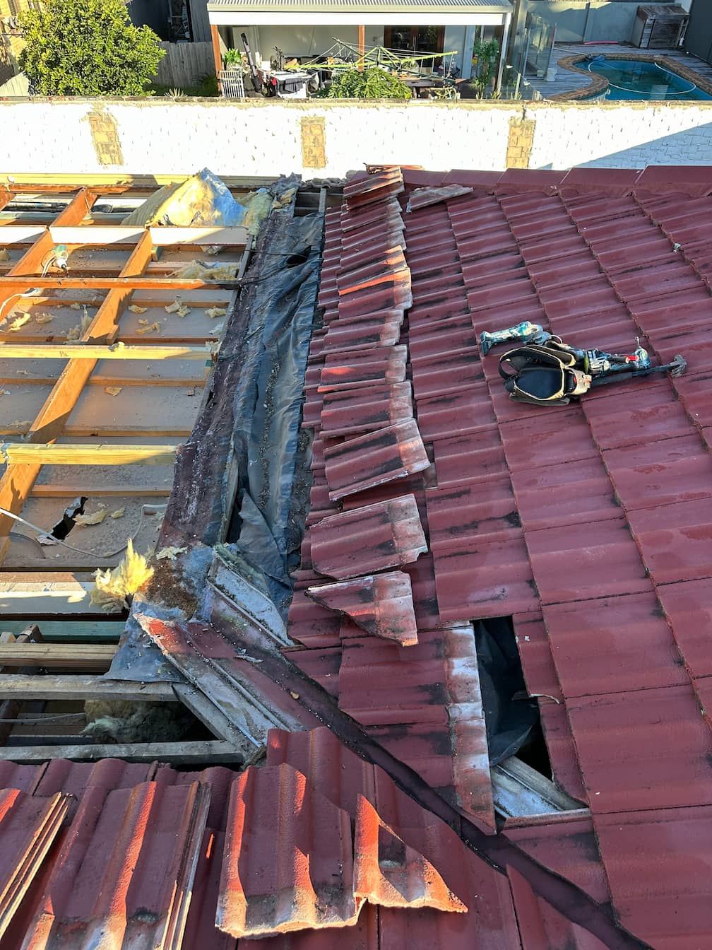 A Gold Coast roof with a lot of tiles missing and a hole in it.