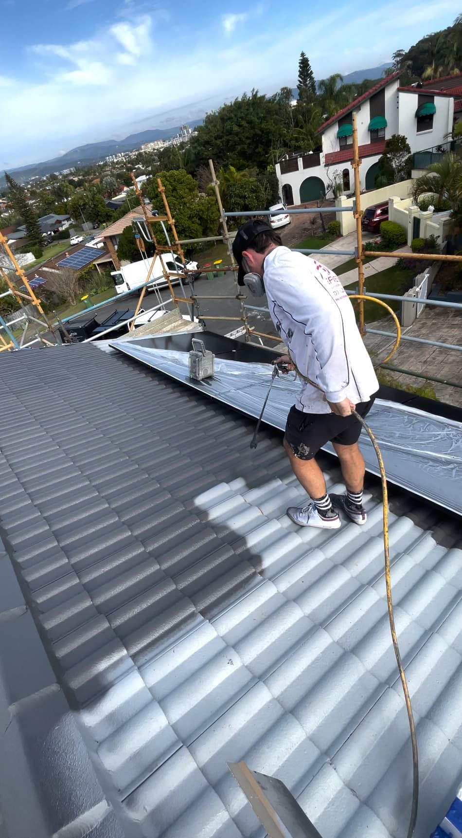 A person painting a roof in Tugun
