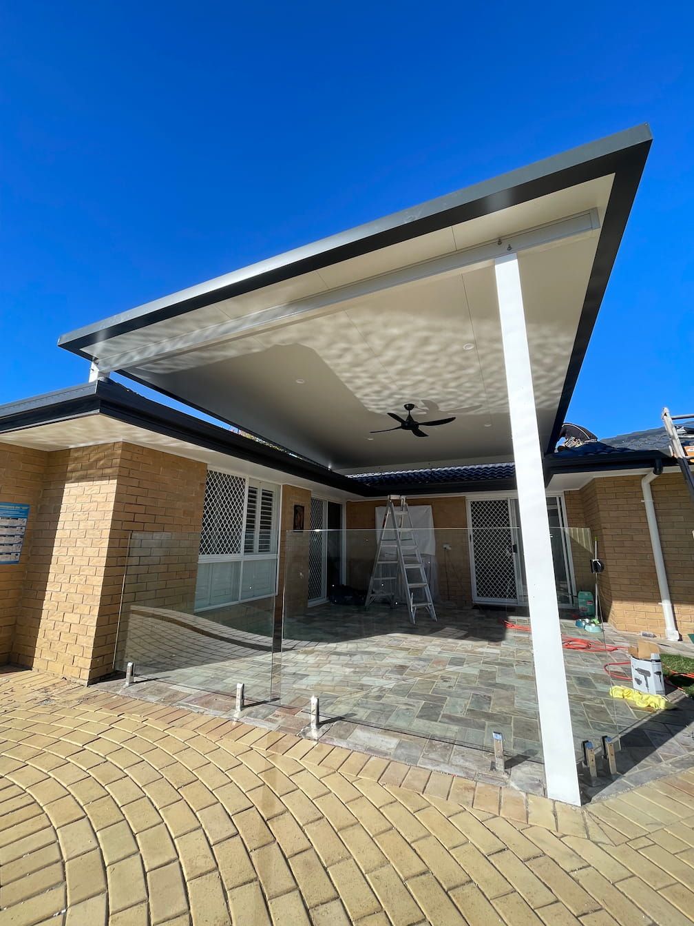 A Gold Coast house with a covered patio and a ceiling fan.