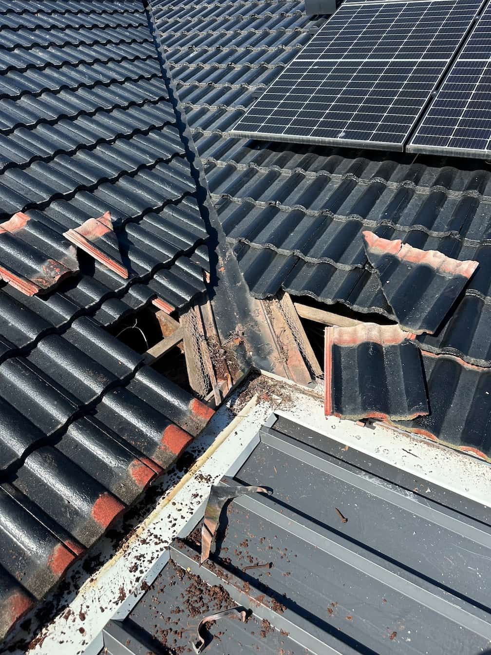 A Gold Coast roof with a hole in it and solar panels on it.