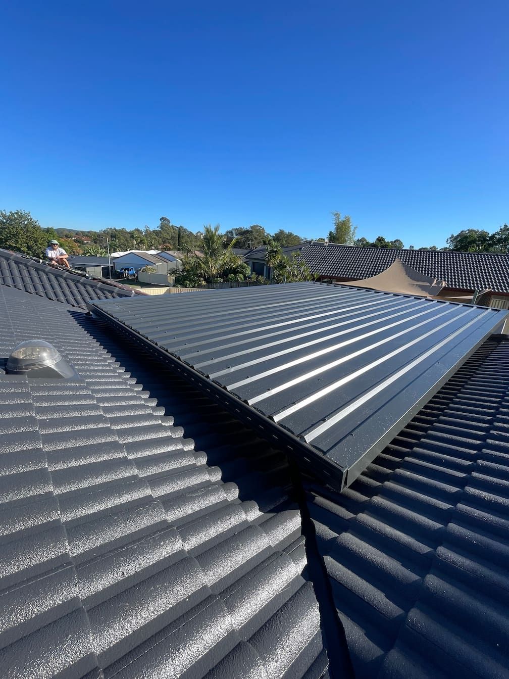 A close up of a roof with a blue sky in the background.