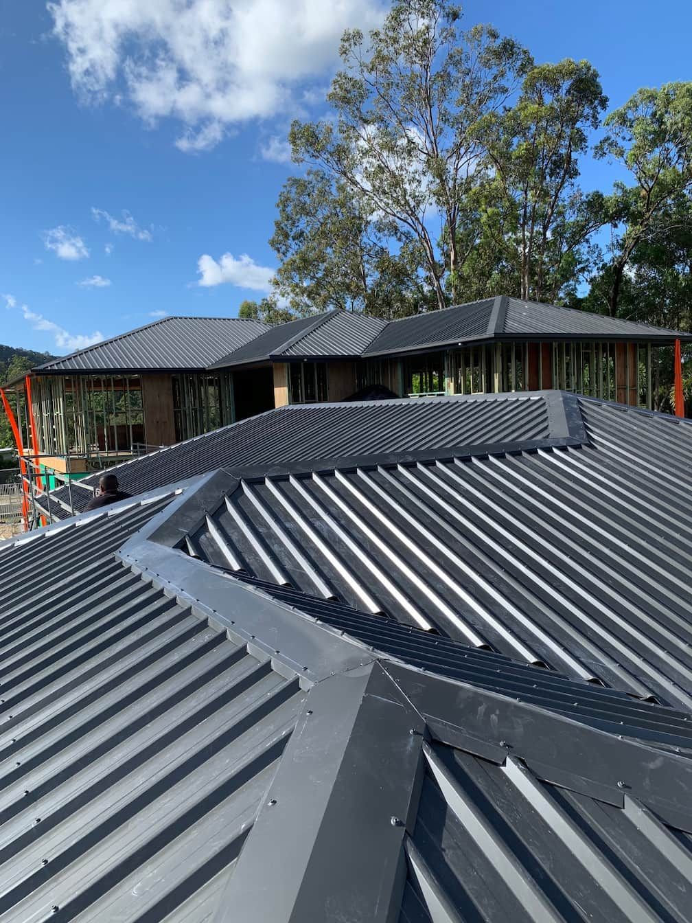 A large house with a metal roof is being built.