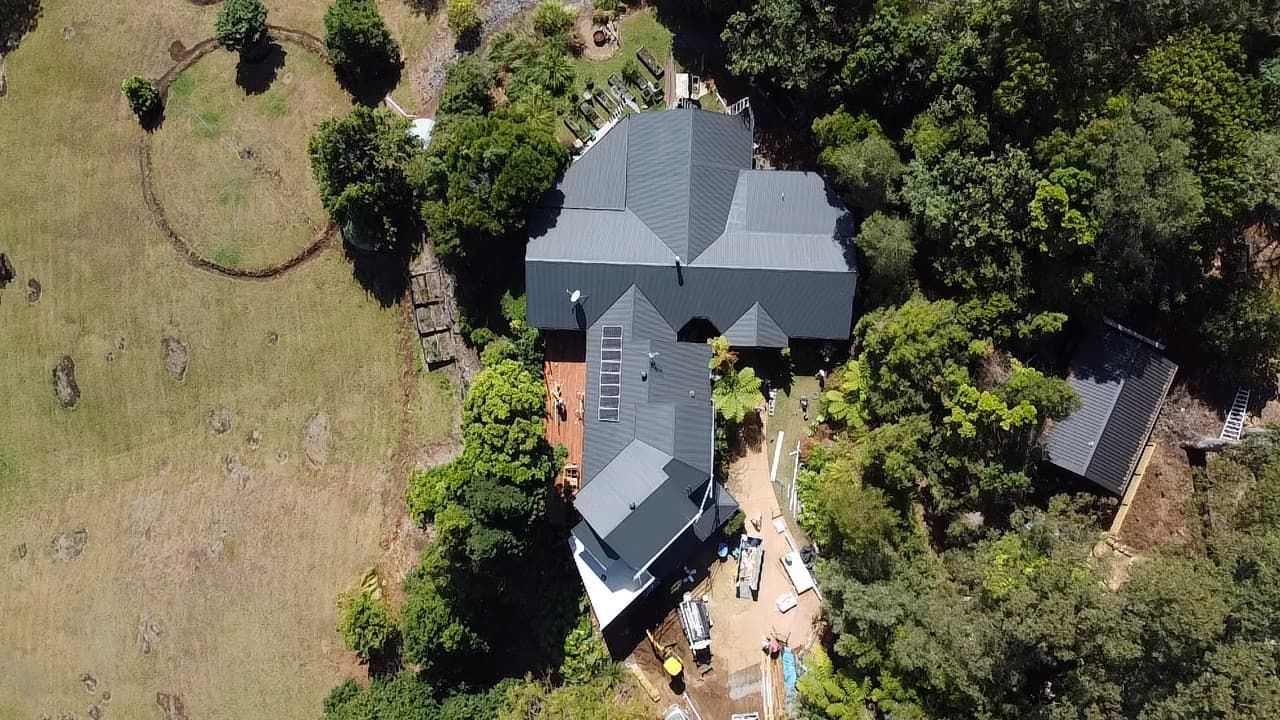 An aerial view of a large house surrounded by trees and grass.