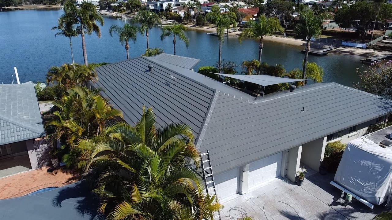 An aerial view of a Gold Coast house with a roof overlooking a body of water.