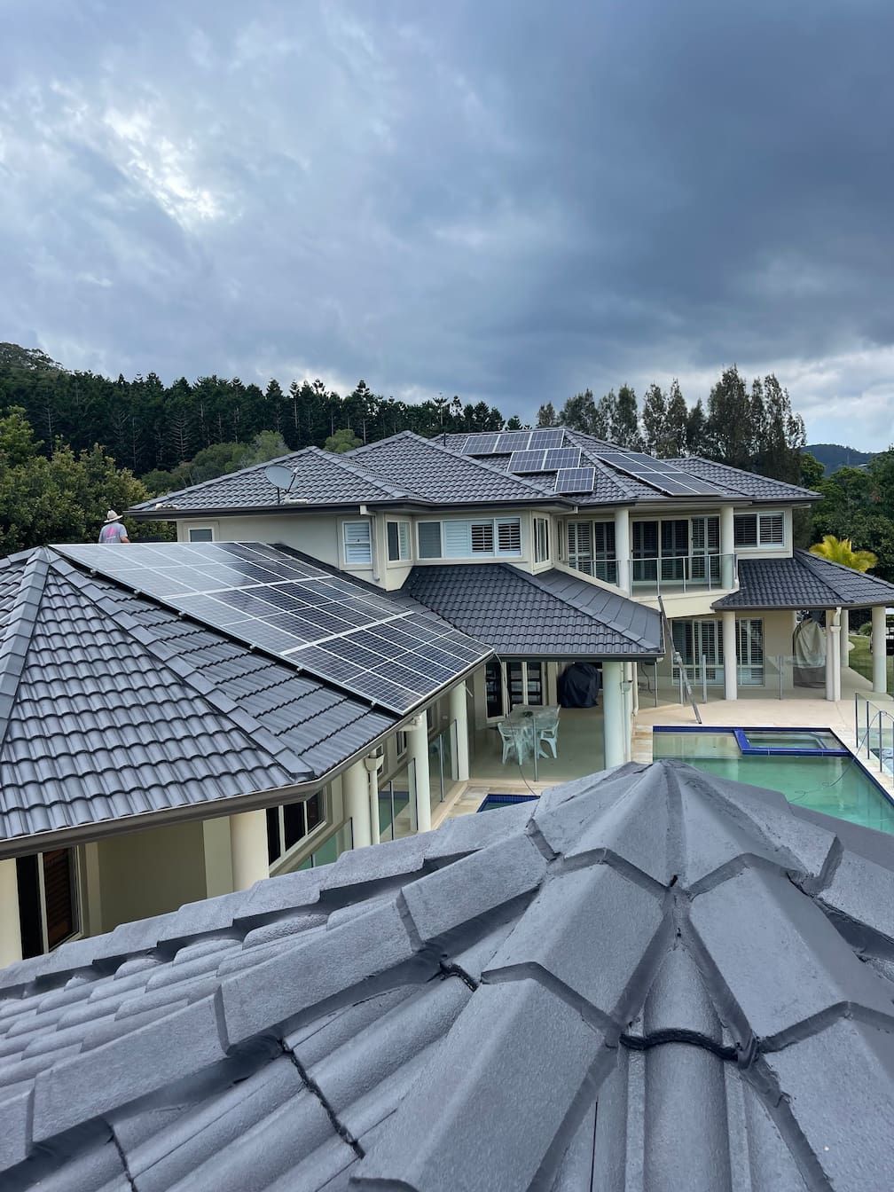 A large Gold Coast house with a swimming pool and solar panels on the roof.