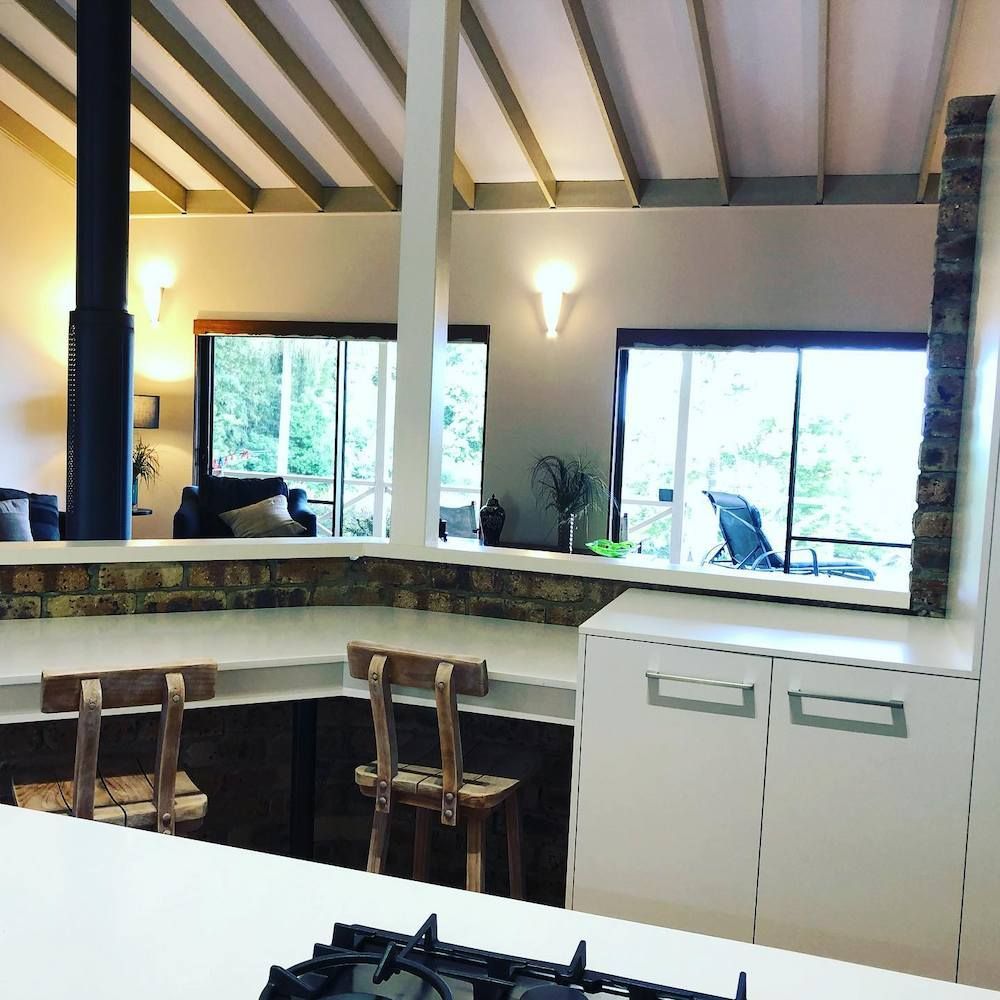 A Kitchen With A Stove Top Oven And Chairs — Alstonville Kitchens In Alstonville, NSW