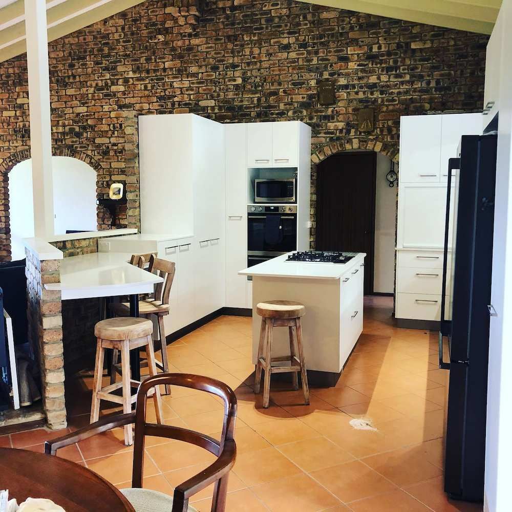 A Kitchen With White Cabinets And A Brick Wall — Alstonville Kitchens In Alstonville, NSW