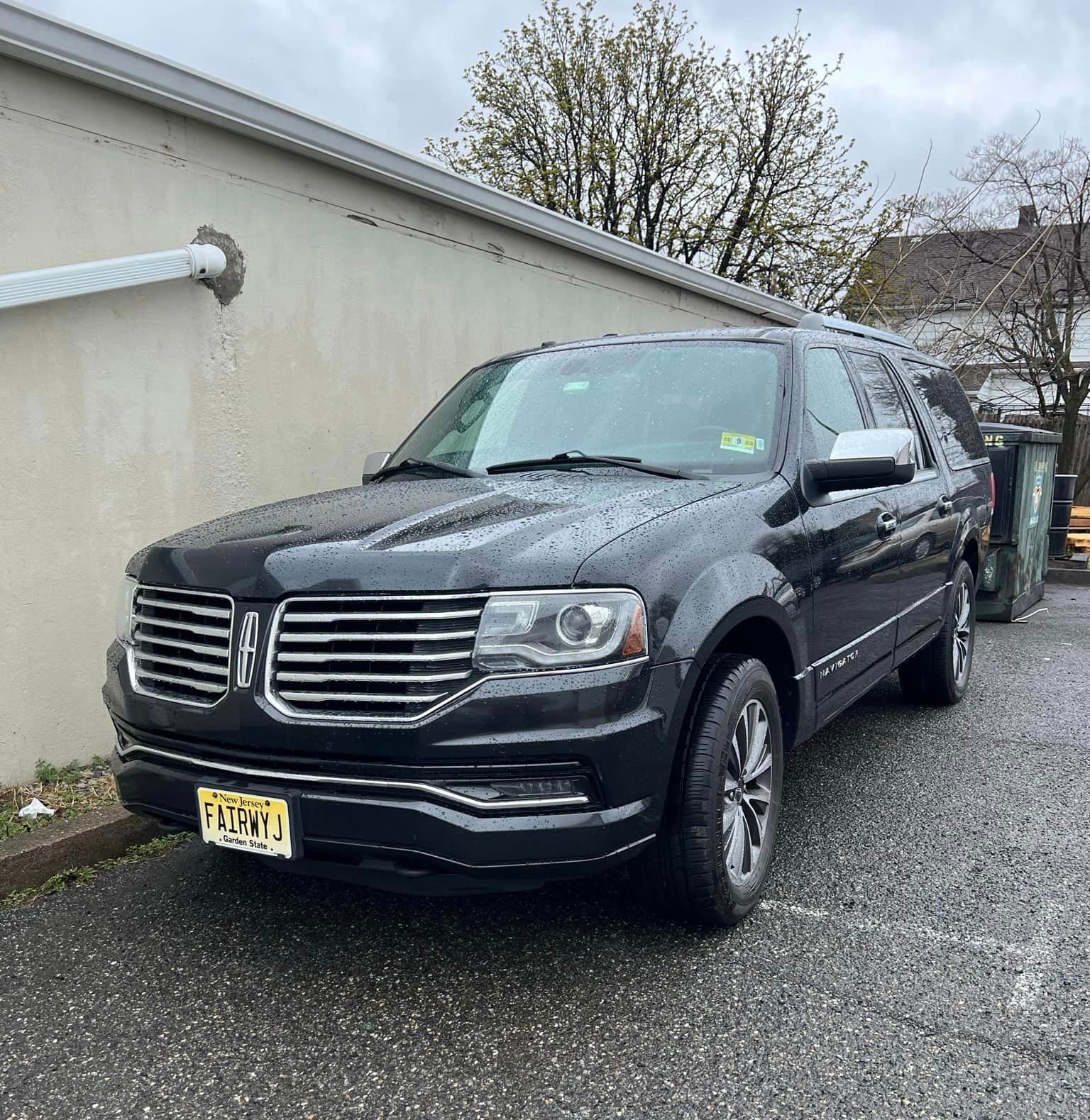A black ford expedition is parked in a parking lot.