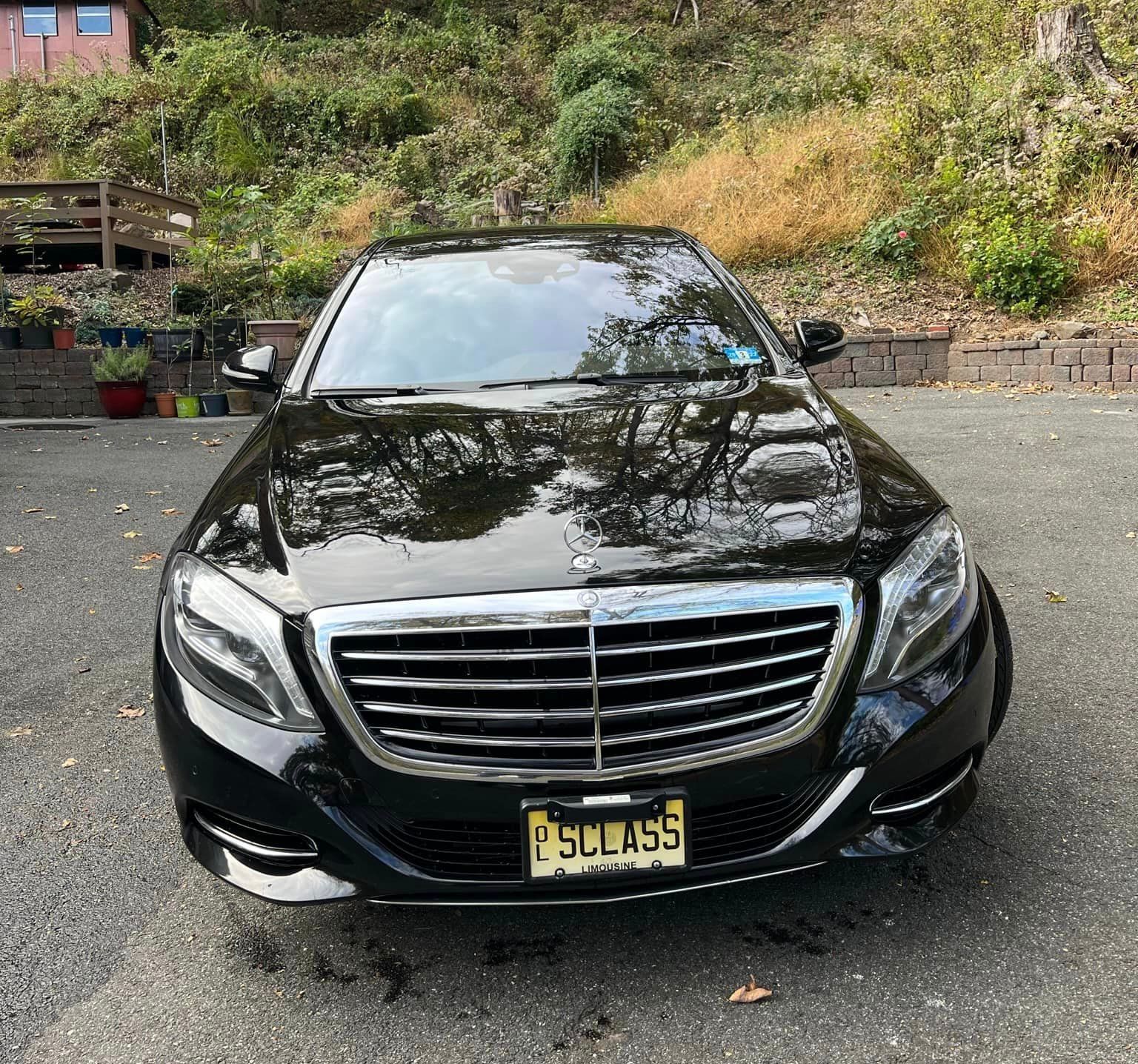 A black mercedes benz is parked in a parking lot