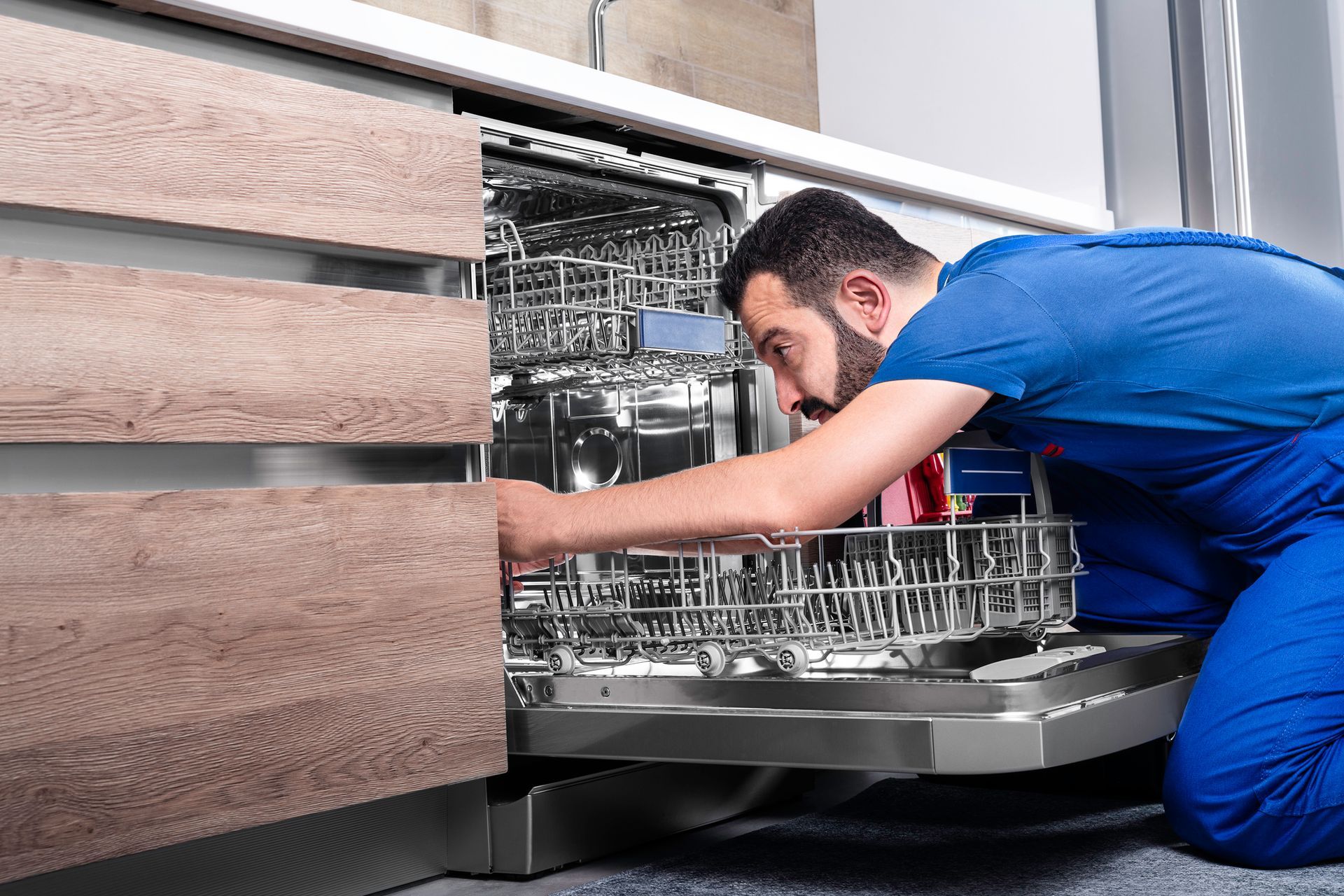 Appliance repair specialist performing maintenance on a dishwasher.