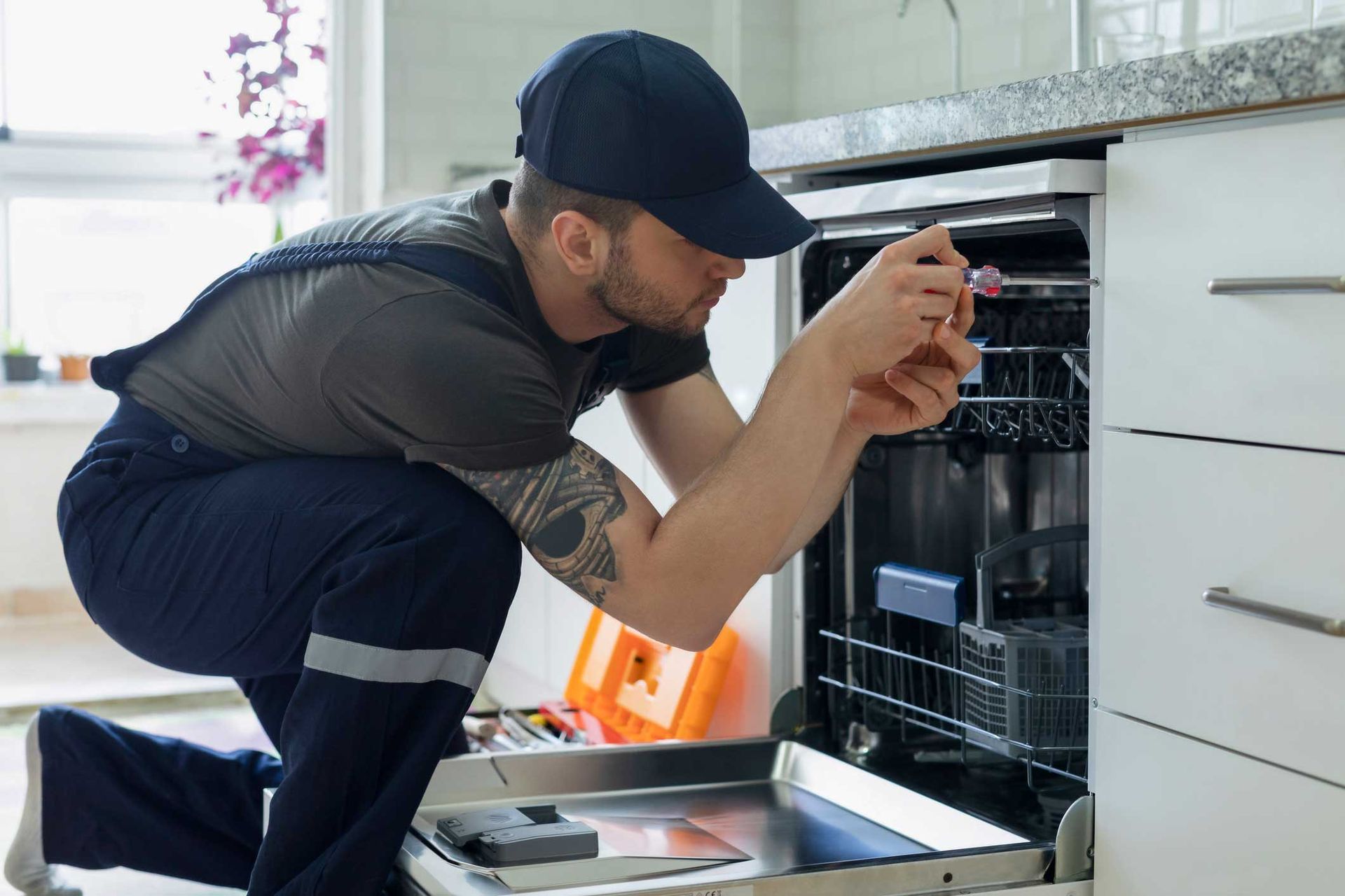 Man Repairing Dishwasher — High Point, NC — Appliance & Repair Man Repairing Dishwasher — High Point, NC — Appliance & Repair