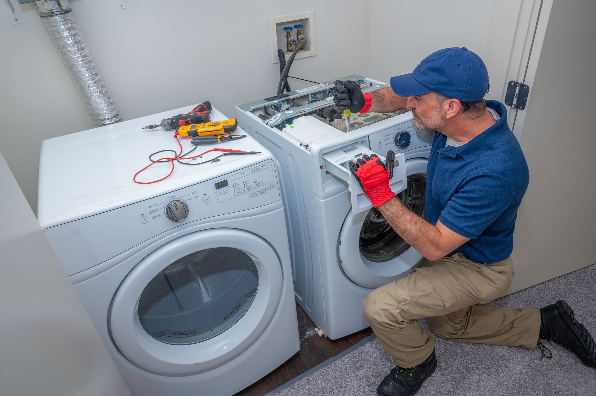 Appliance & Repair technician performing appliance repair in Greensboro, NC, fixing a washing machin
