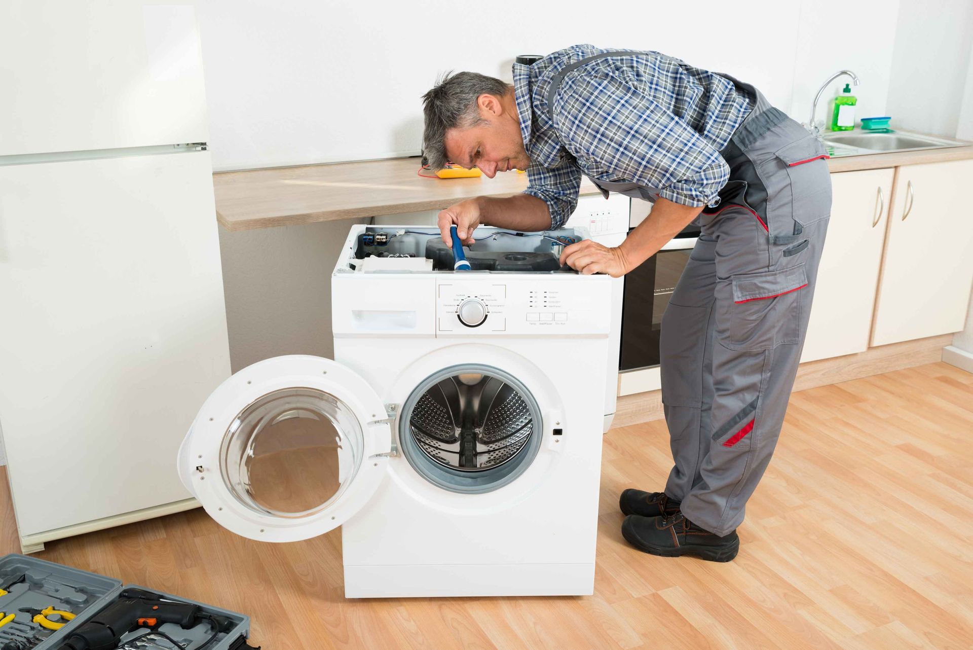 Man Repairing Washing Machine — High Point, NC — Appliance & Repair Man Repairing Washing Machine — High Point, NC — Appliance & Repair