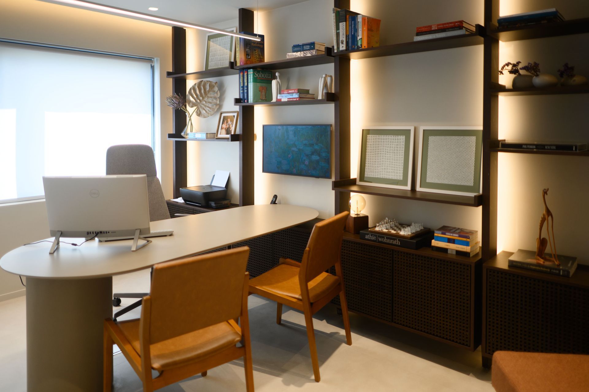 Escritório moderno em casa com mesa, cadeiras, prateleiras de parede, obras de arte e uma janela bem iluminada.
