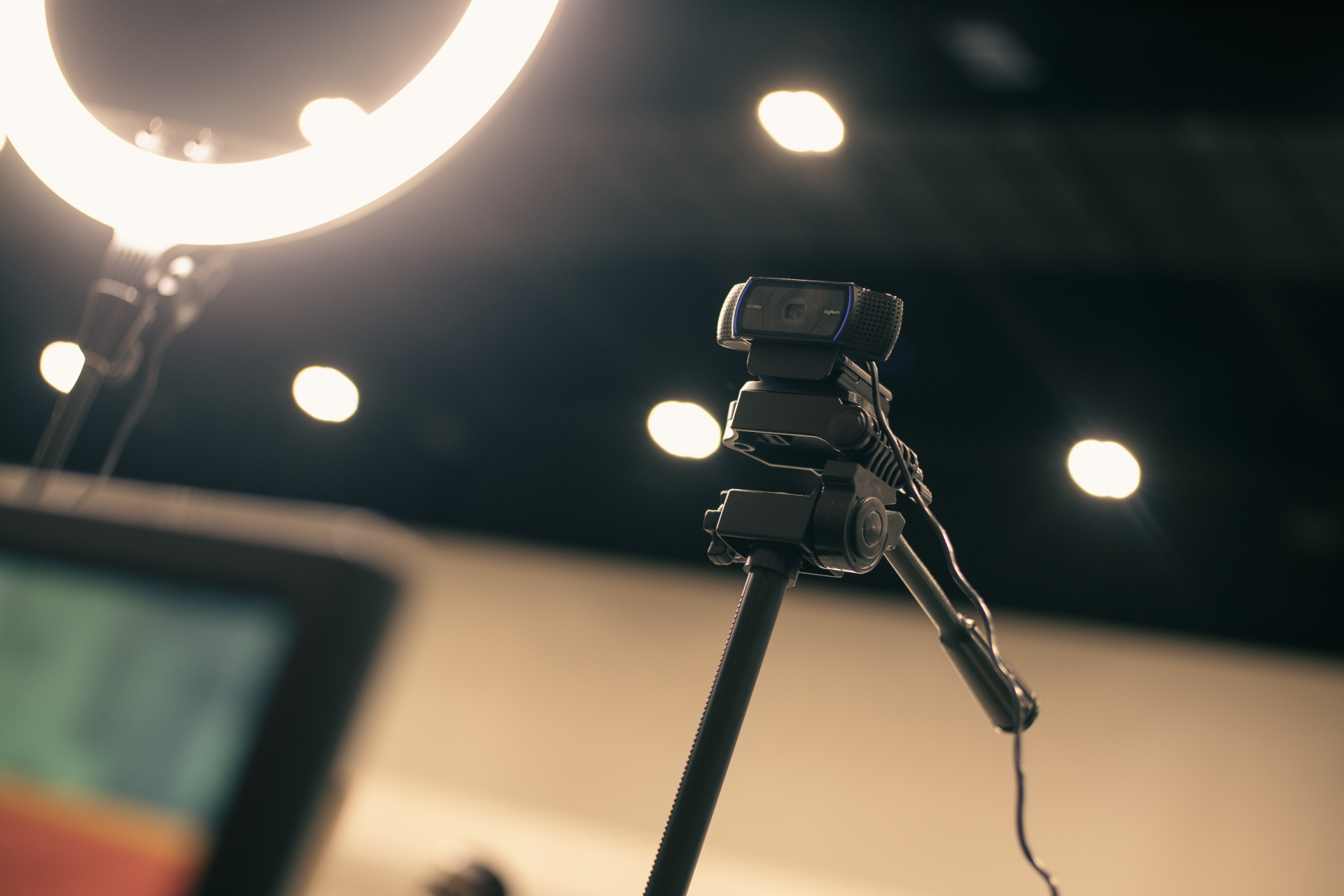 Webcam mounted on tripod with ring light in bright studio.