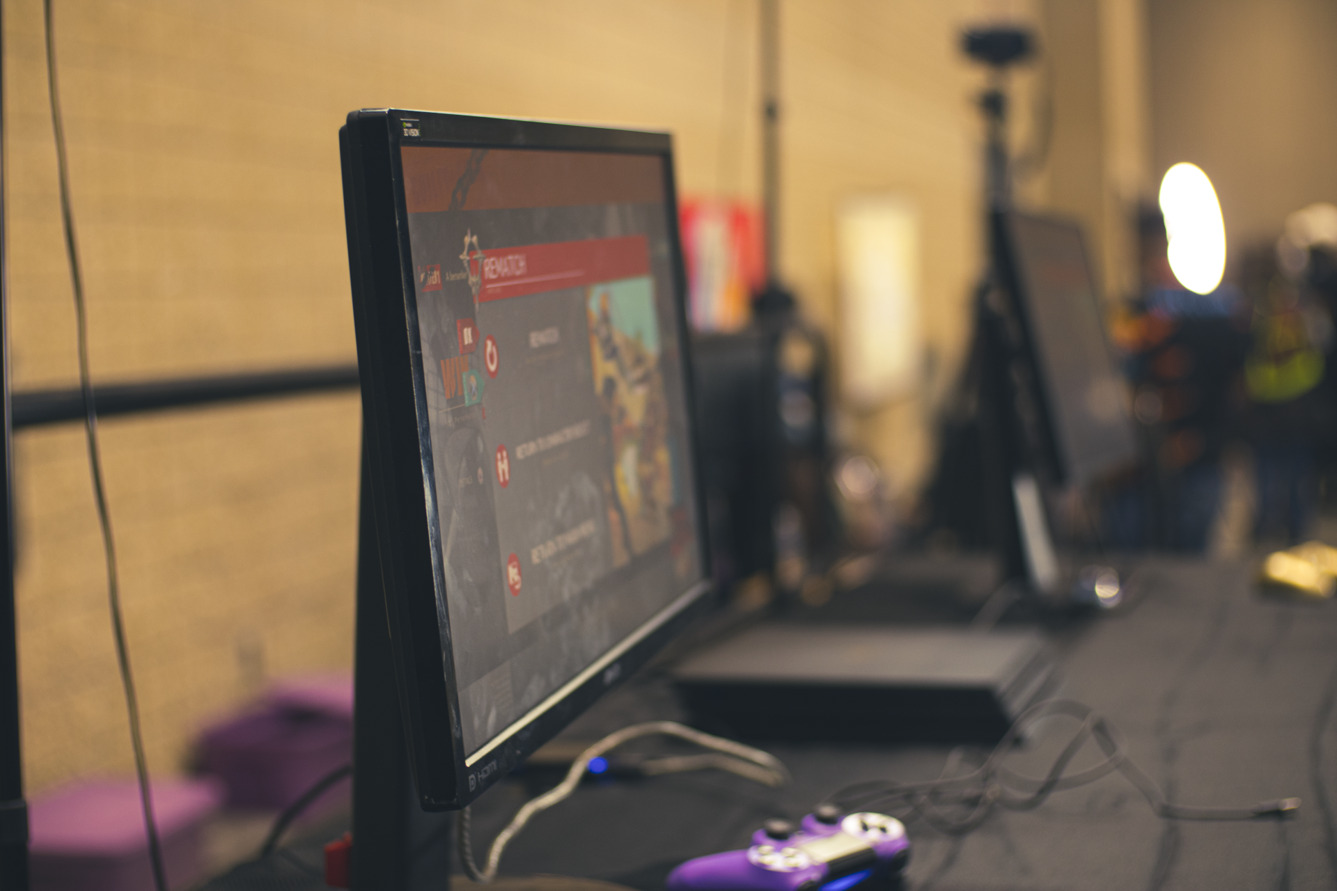 Computer monitor displaying a game interface, with a purple game controller in front.