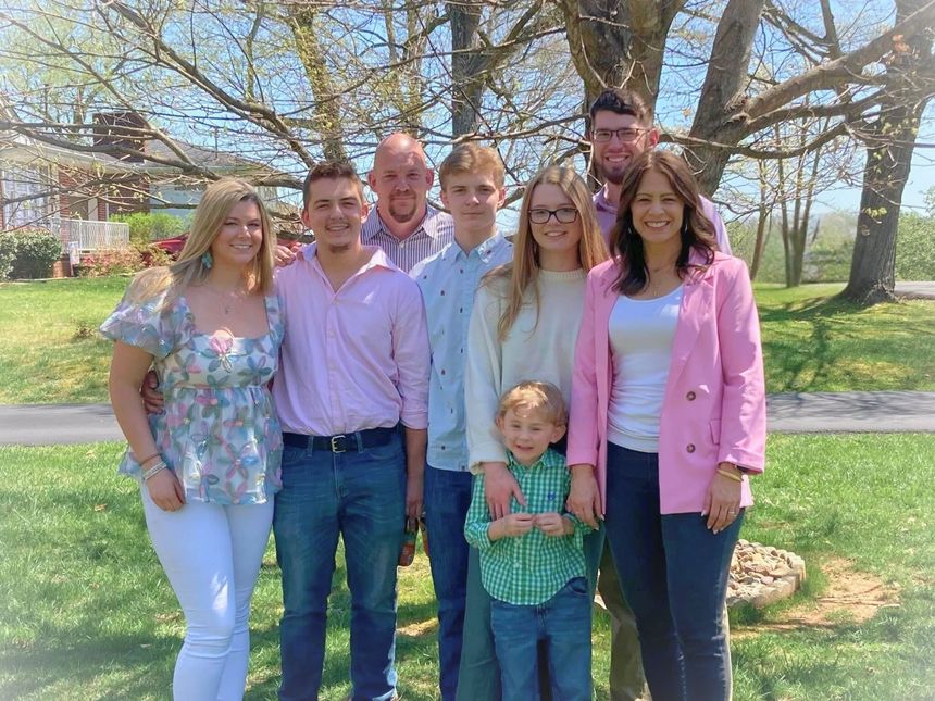 Family of eight poses in a sunny yard | Almen Enterprises