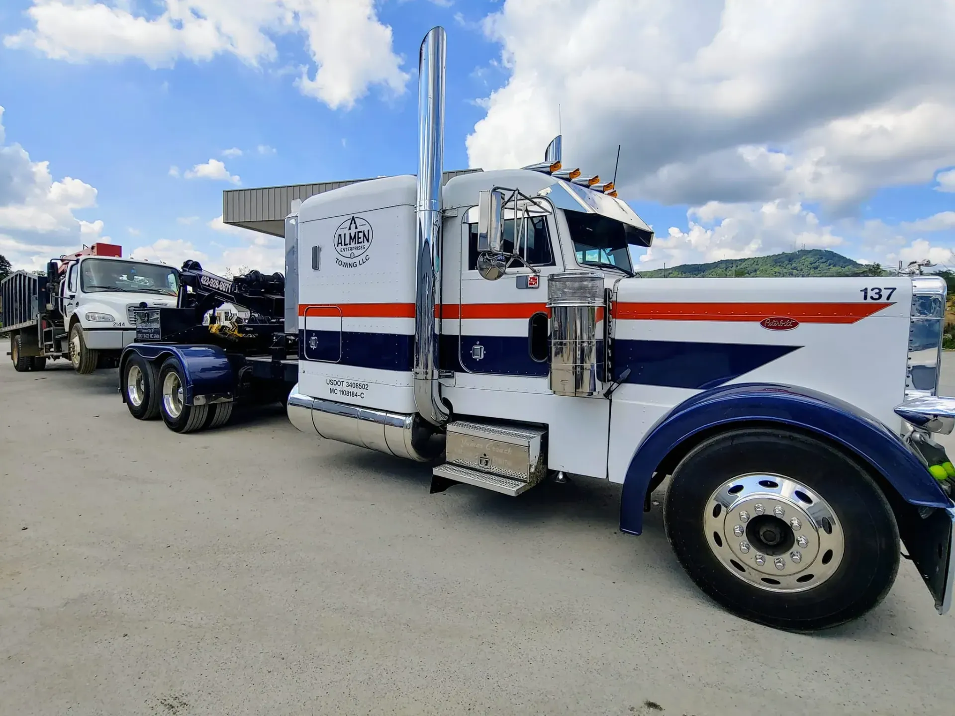 Two semi trucks are parked next to each other in a parking lot.