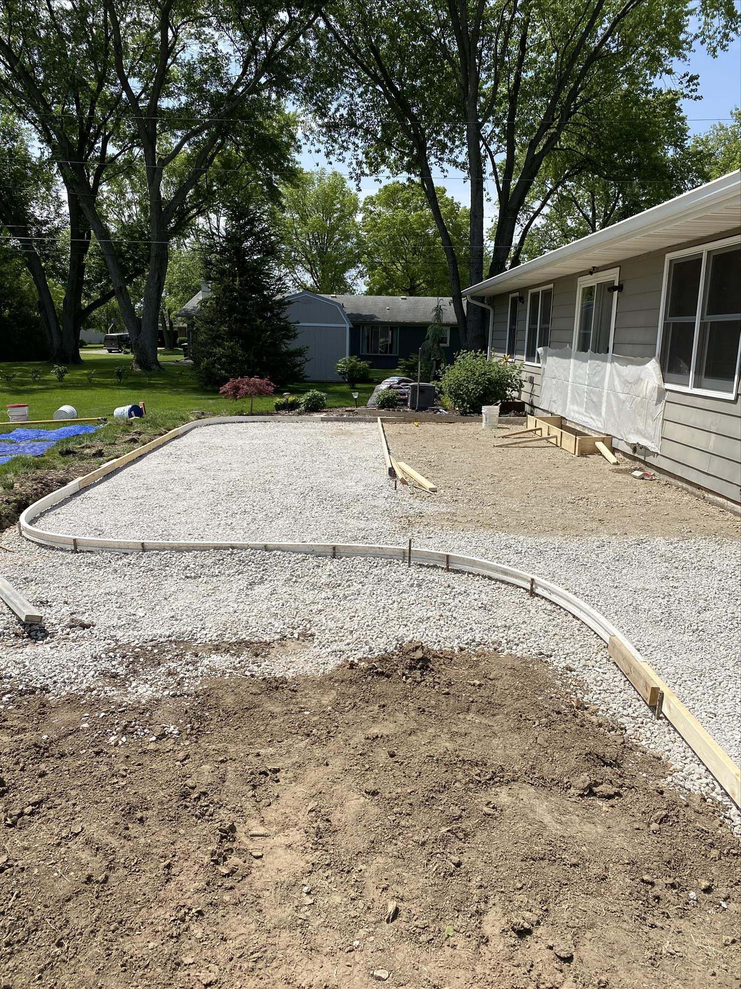 A driveway is being built in front of a house.