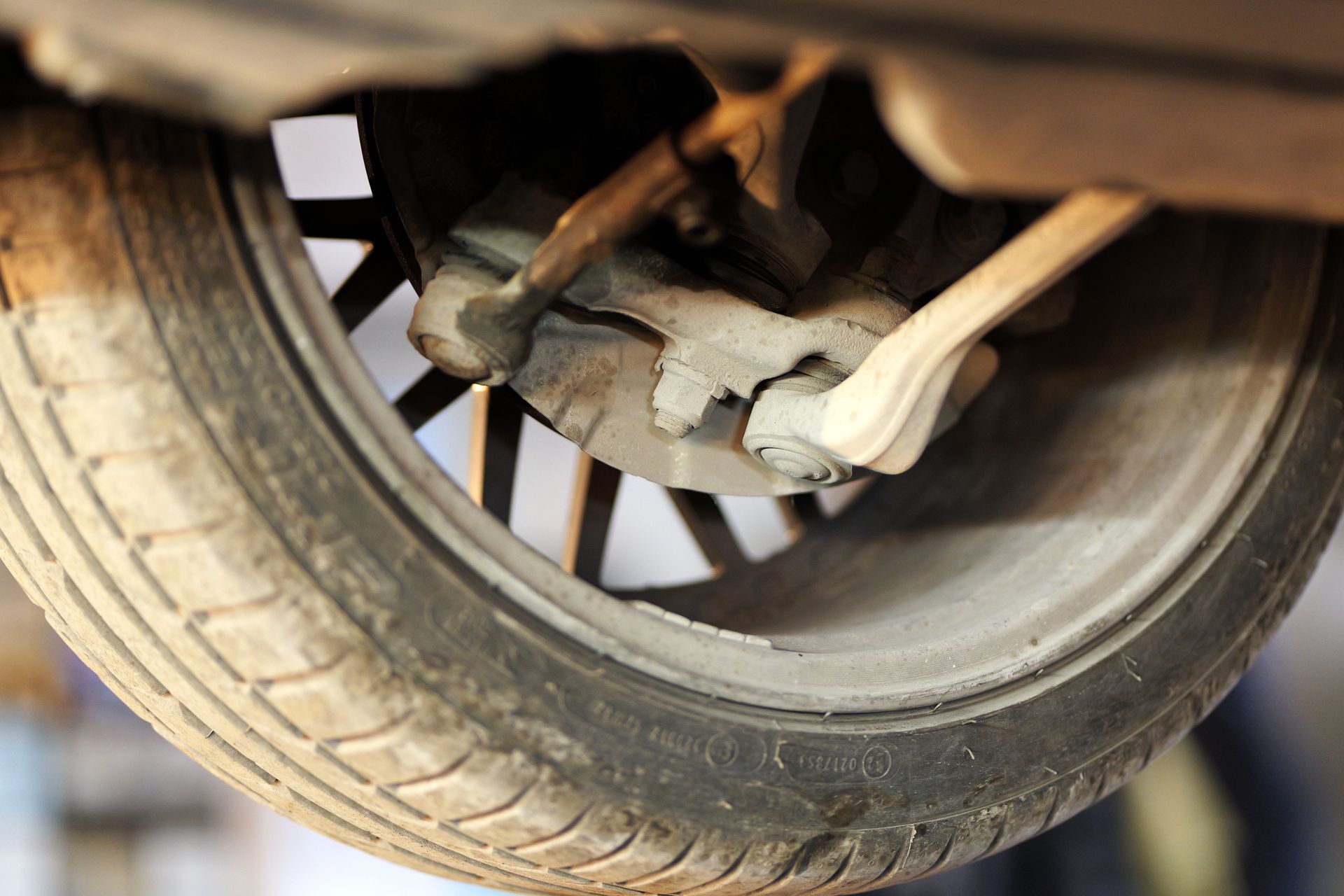 Close-up of a car wheel with a damaged suspension or brake component underneath.