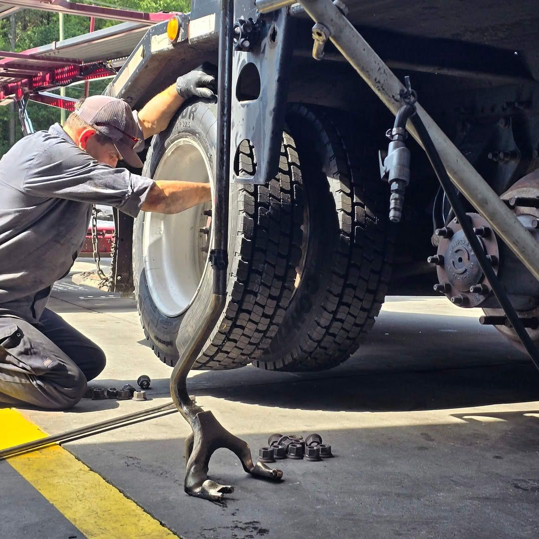 A man is working on a truck tire in a garage