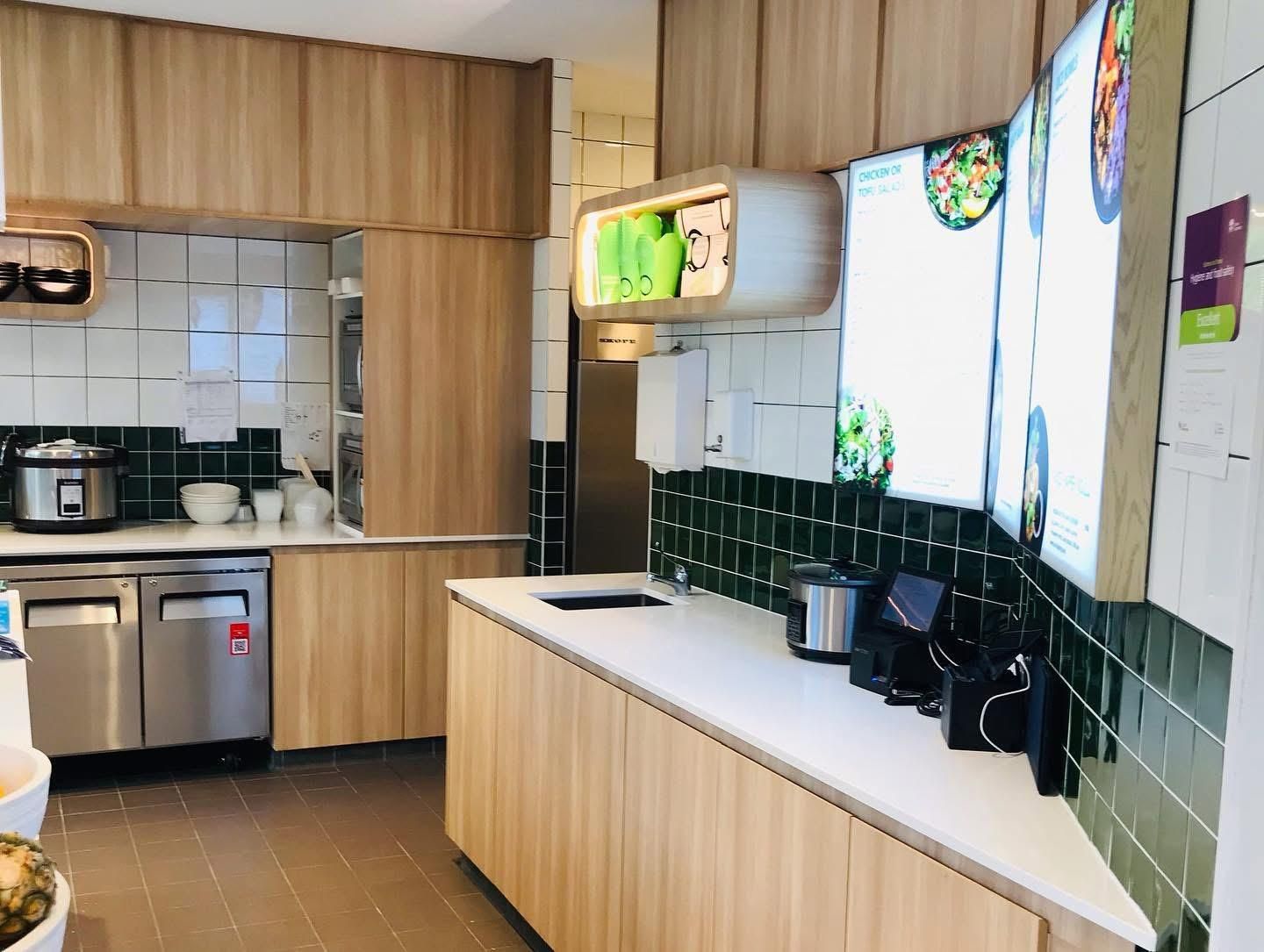 A Kitchen With Wooden Cabinets and Stainless Steel Appliances — Nyon Shopfitters in Morisset, NSW