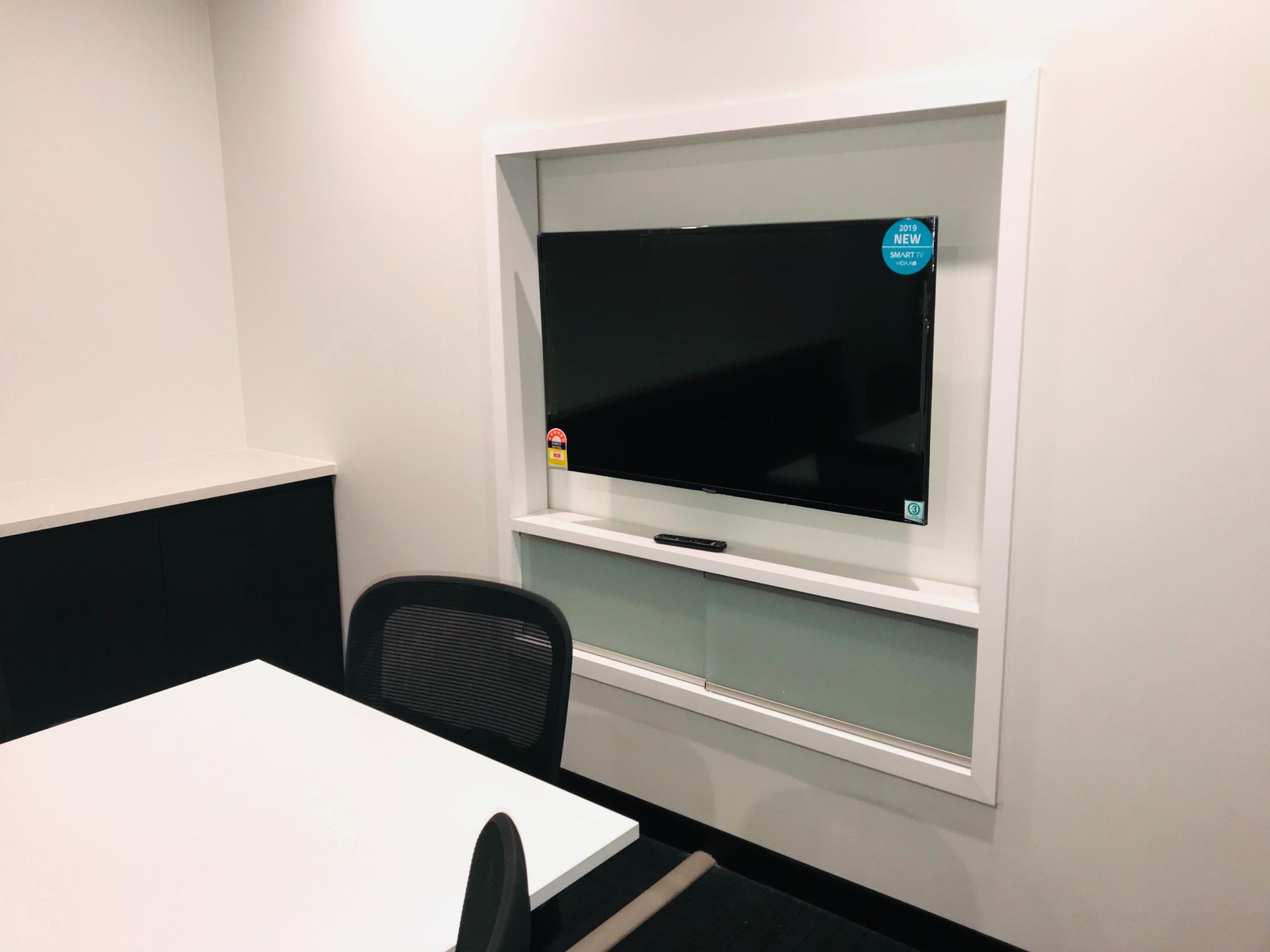 A Conference Room With a Table and Chairs and a Flat Screen TV on the Wall — Nyon Shopfitters in Morisset, NSW
