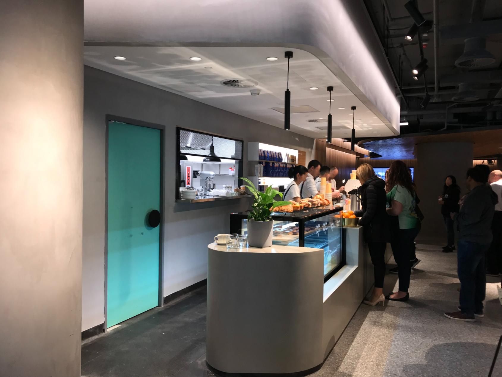 A Group of People Are Standing Around a Counter in a Restaurant — Nyon Shopfitters in Morisset, NSW