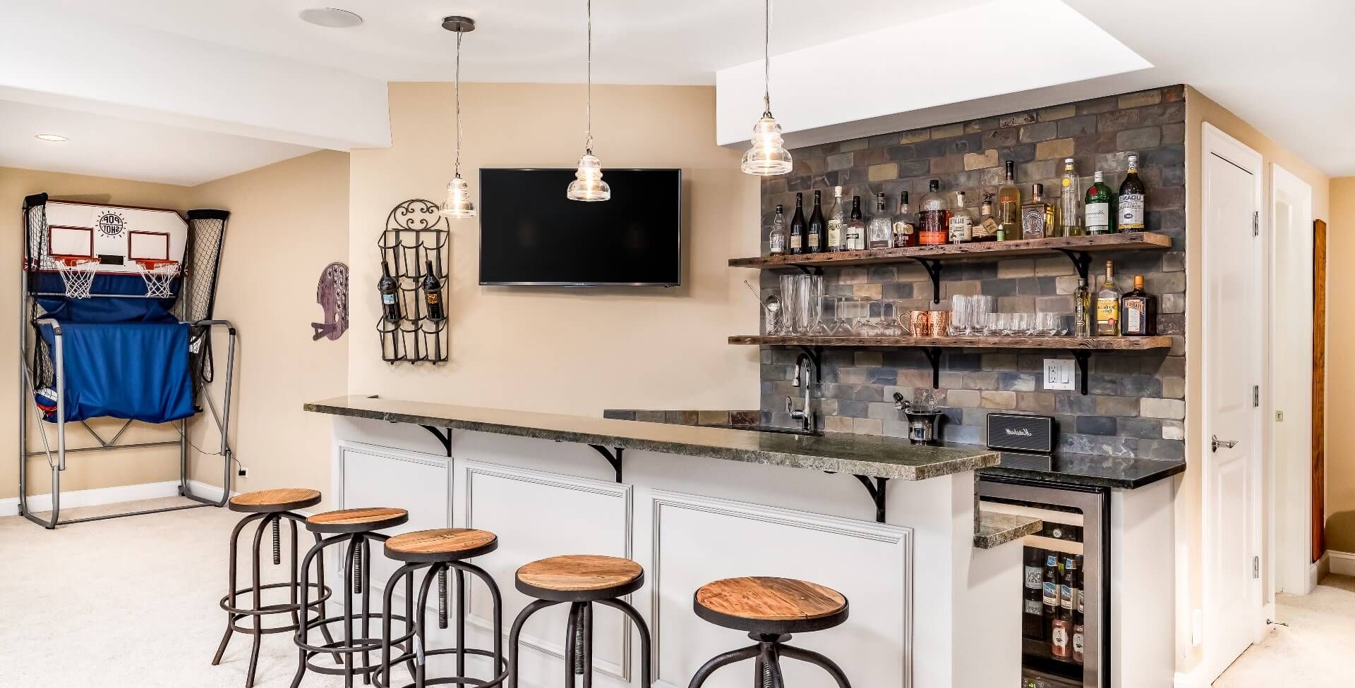 A bar, bar stools, TV, and a portable basketball court are essential for an epic man cave
