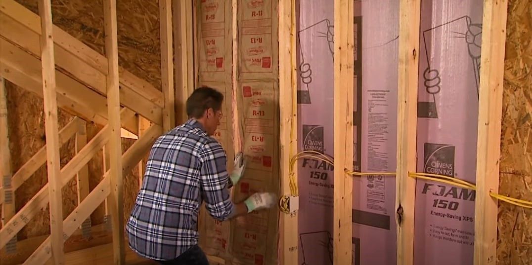Expert installing basement wall insulation for optimal energy efficiency.