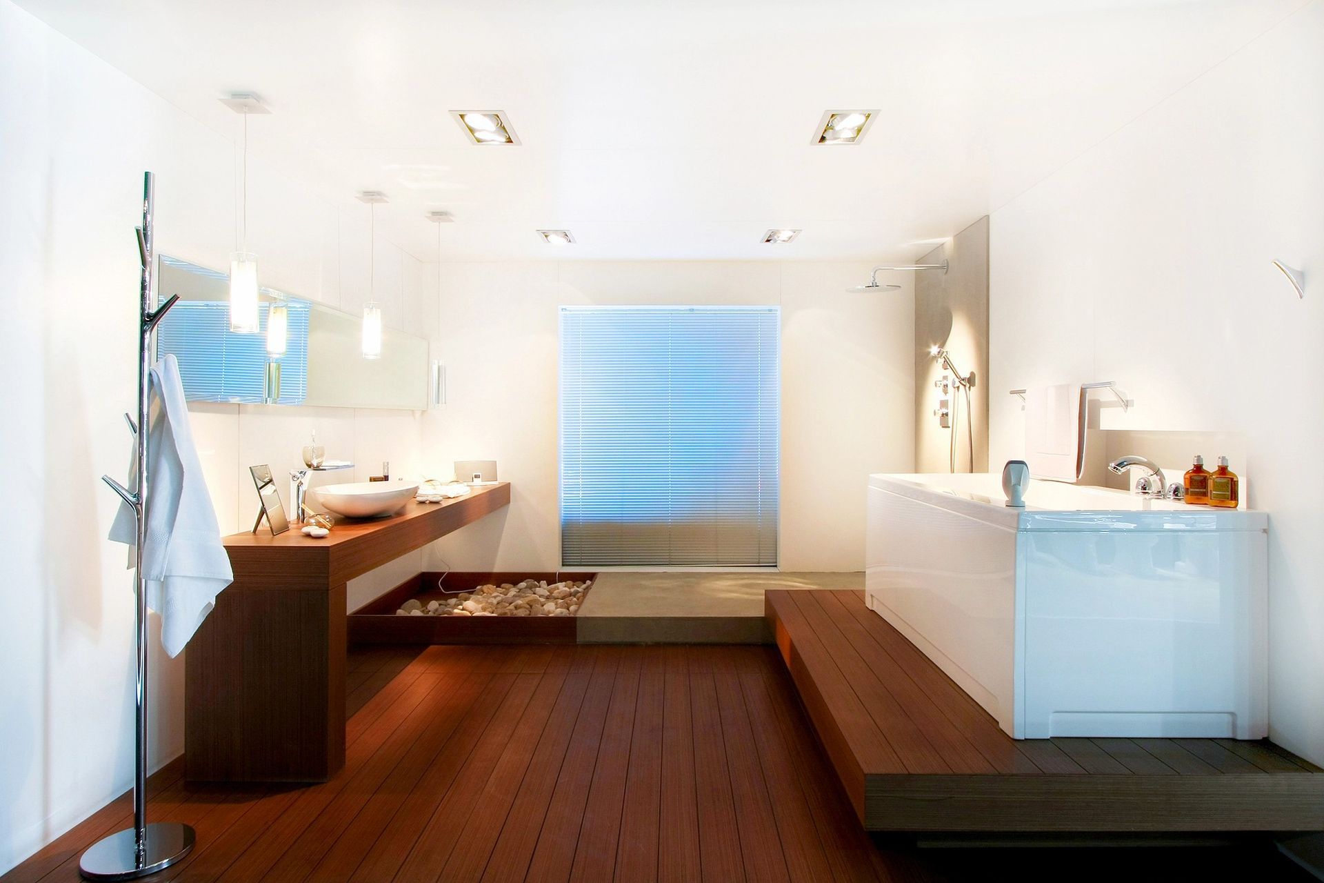 Modern bathroom with freestanding bathtub, stylish sink, and wooden flooring.