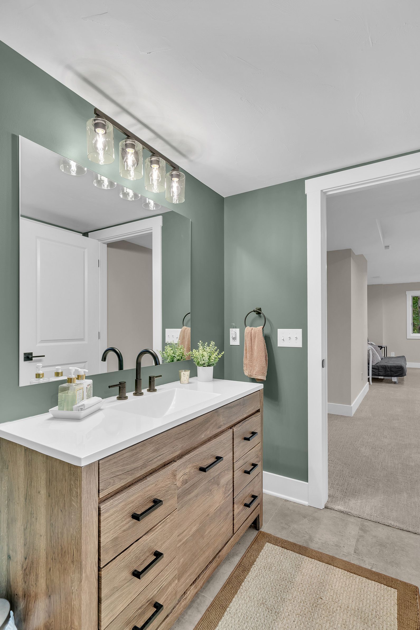 A bathroom with a sink , mirror and dresser.