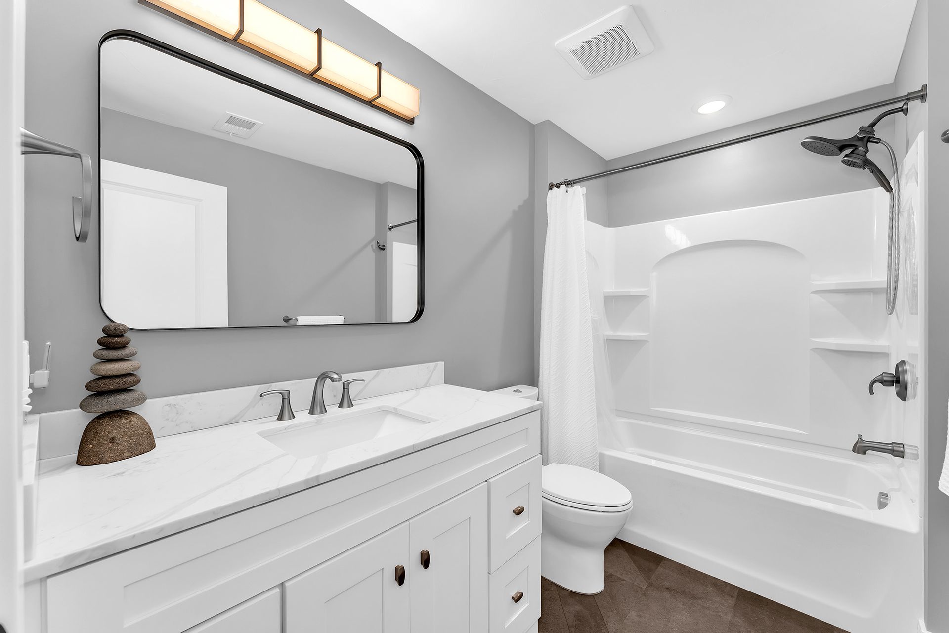 A bathroom with a sink , toilet , tub and mirror.