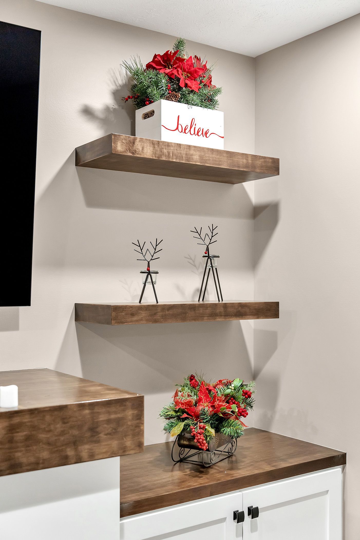 A shelf with two reindeer and flowers on it