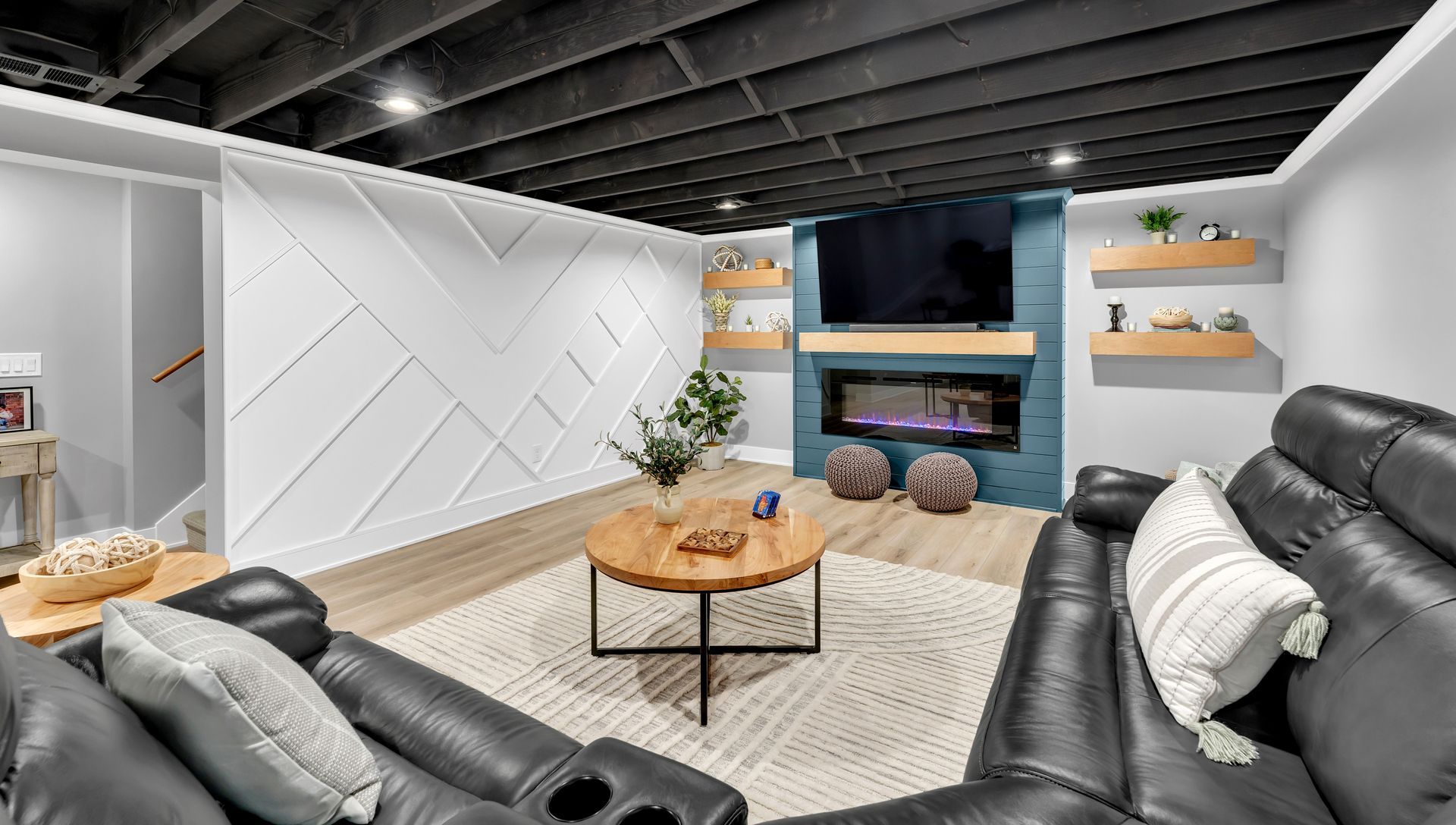A living room with a couch , chairs , table and television.
