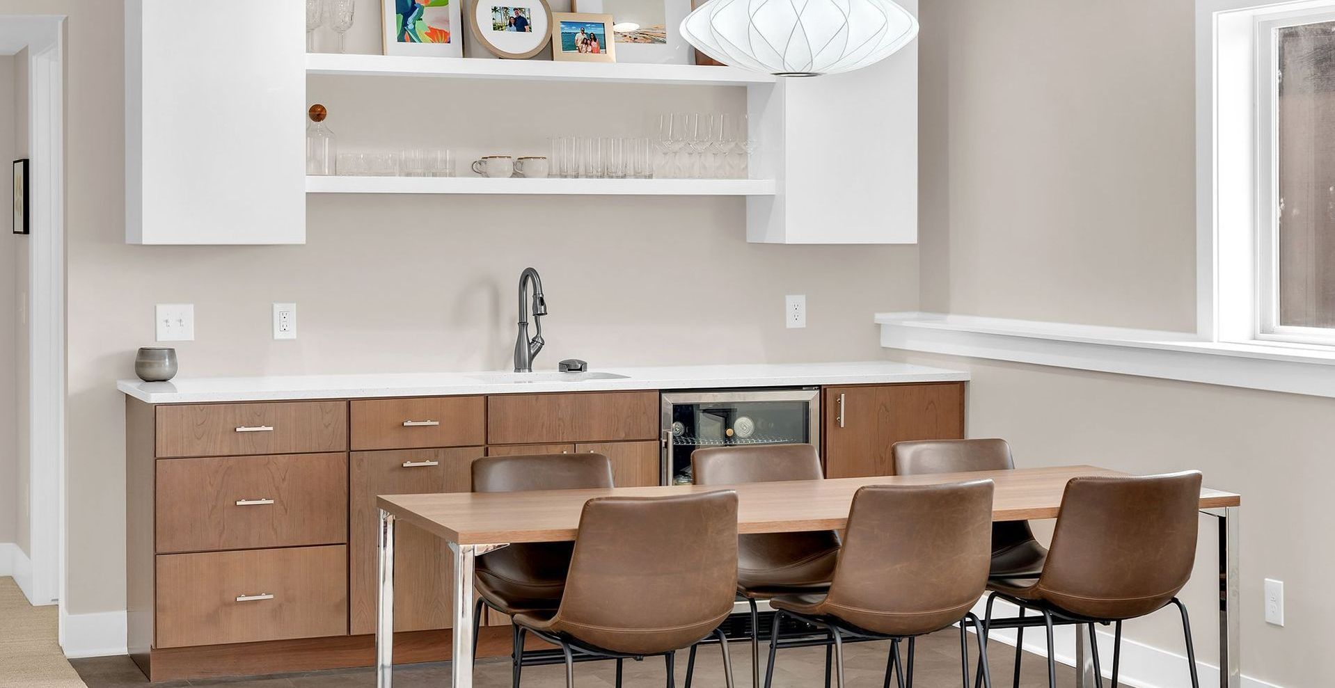 A kitchenette with a table and chairs and a sink.