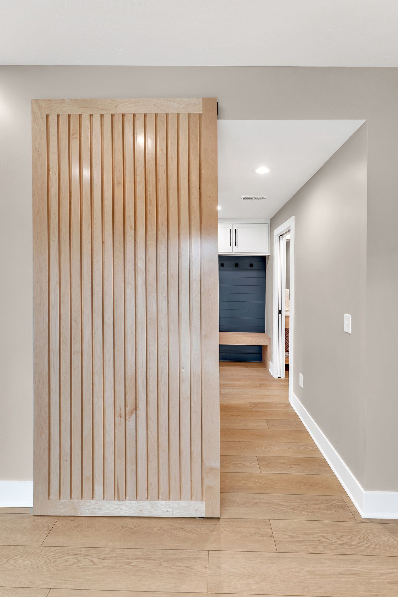 A hallway with a wooden sliding door between two rooms.