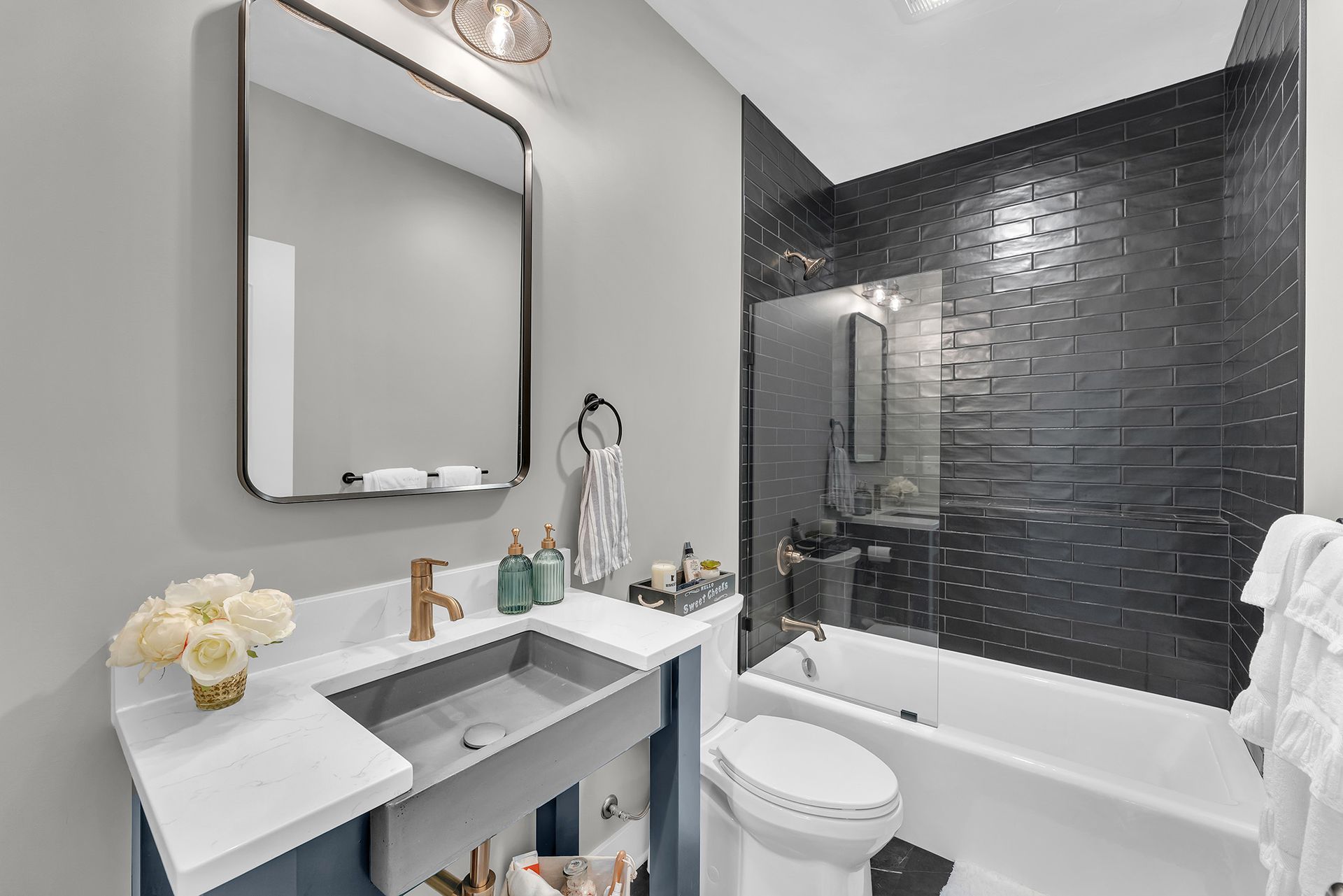 A bathroom with a sink , toilet , bathtub and mirror.